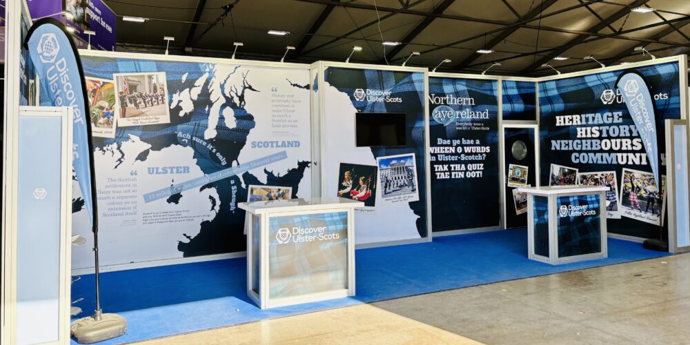 Exhibition booth featuring large map of Ulster and Scotland with informational displays about shared heritage and history.