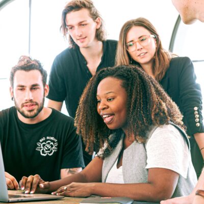 A group of people looking at a laptop together